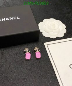 Chanel pink earrings with packaging on black surface.