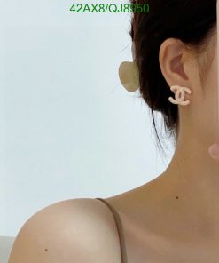 Woman wearing designer logo earring.