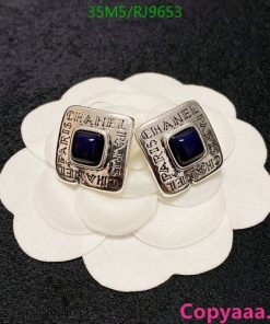 Designer square rings with blue gemstones on flower display.