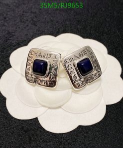 Designer rings with blue stones on white petal background.