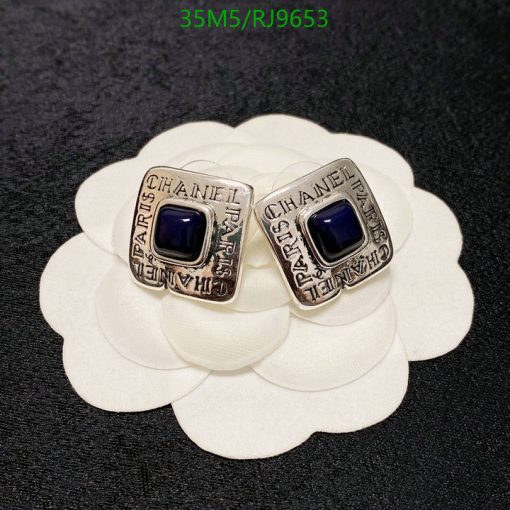 Designer rings with blue stones on white petal background.