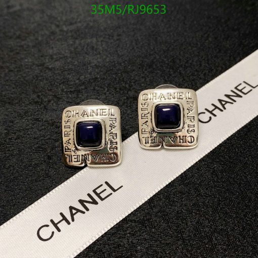 Designer square earrings with blue stones on branded ribbon.