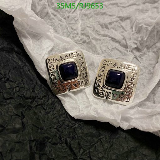 Designer silver cufflinks with blue stones on crinkled paper.