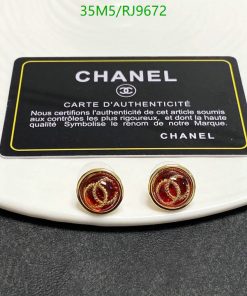 Chanel authenticity card and logo earrings on white surface.