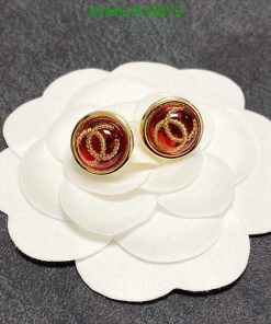 Gold-tone logo stud earrings on white display.