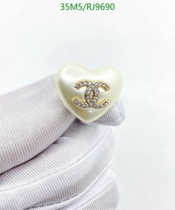 Heart-shaped pendant with emblem on white fabric.