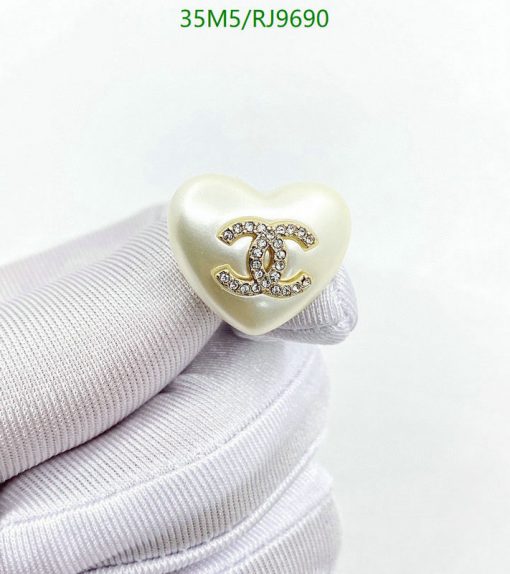 Heart-shaped pendant with emblem on white fabric.