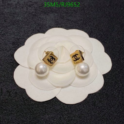 Designer pearl earrings on white flower display.