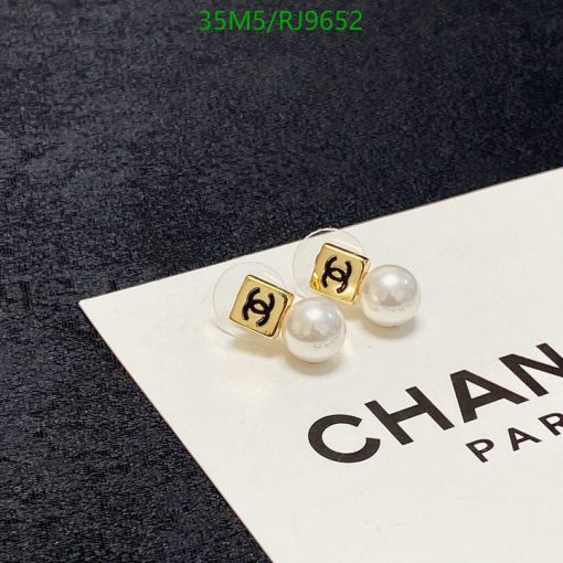 Gold pearl earrings on branded card.