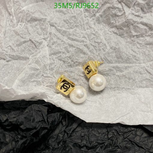 Designer pearl earrings on textured paper background.