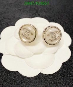 Designer logo earrings on white flower-shaped display.
