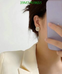 Person taking selfie, showing earring and smartphone
