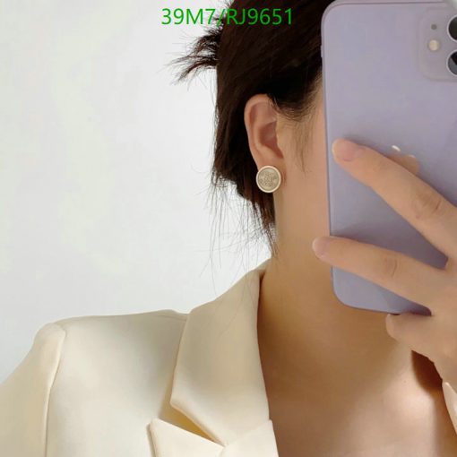 Person taking selfie, showing earring and smartphone