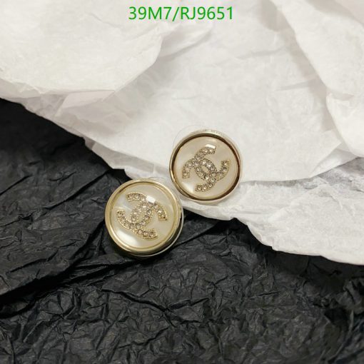 Gold-tone cufflinks with jeweled logos on paper.