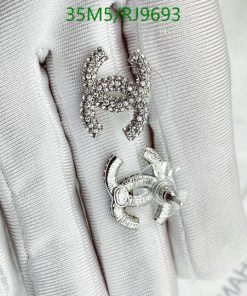 Diamond-encrusted letter H brooch on fabric.