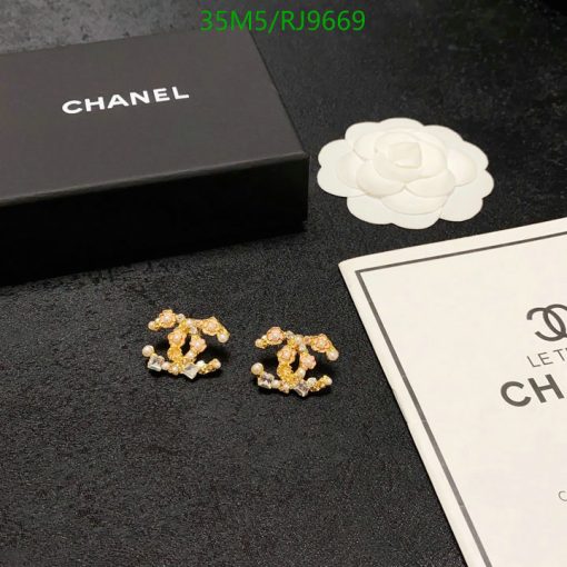 Chanel flower earrings with packaging on black surface.