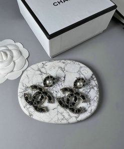 Earrings on marble surface with decorative box.