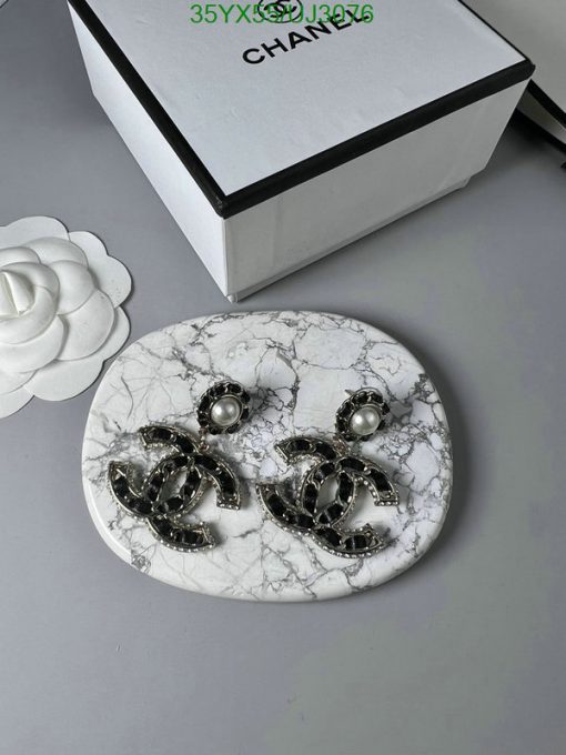 Earrings on marble surface with decorative box.