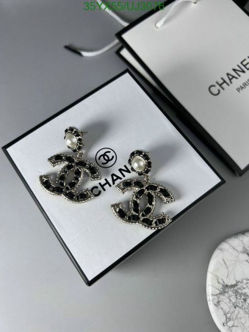 Designer logo earrings displayed on box with brand bag.