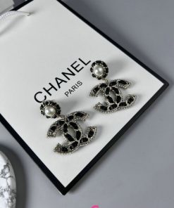 Chanel pearl earrings display on white background.