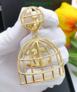 Gold birdcage pendant with gloves, flowers in background.