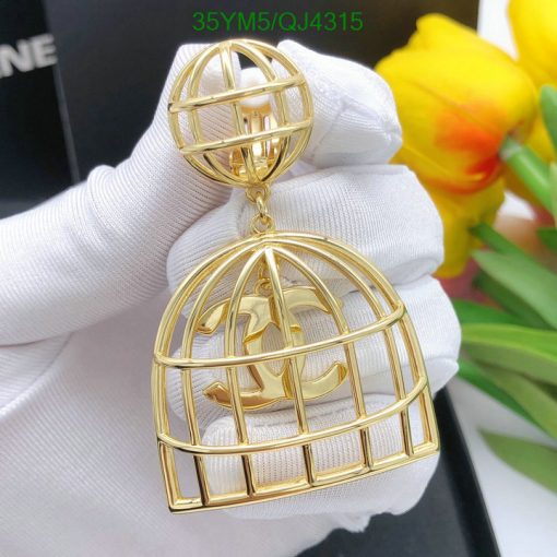 Gold birdcage pendant with gloves, flowers in background.