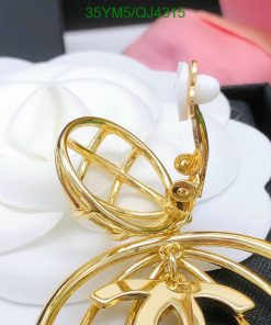 Gold earrings with spherical cage design on white flower.