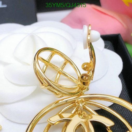 Gold earrings with spherical cage design on white flower.