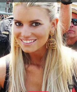 Smiling woman with unique birdcage earrings.