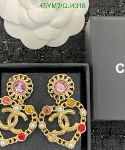 Gold earrings with pearls and colorful gems in box.