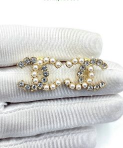 Pearl and crystal brooch on white fabric.