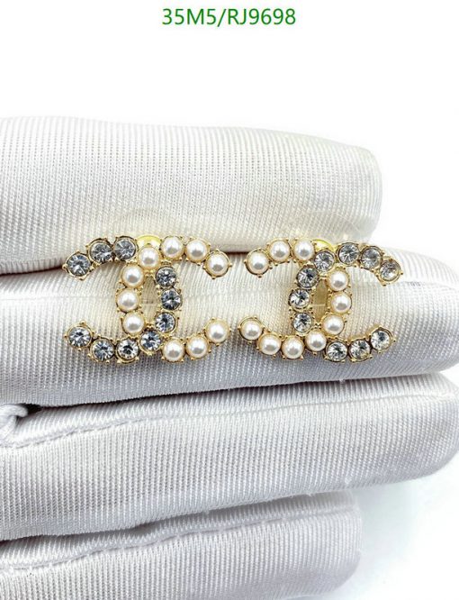 Pearl and crystal brooch on white fabric.