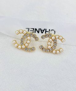 Pearl and rhinestone embellished earrings on fabric.