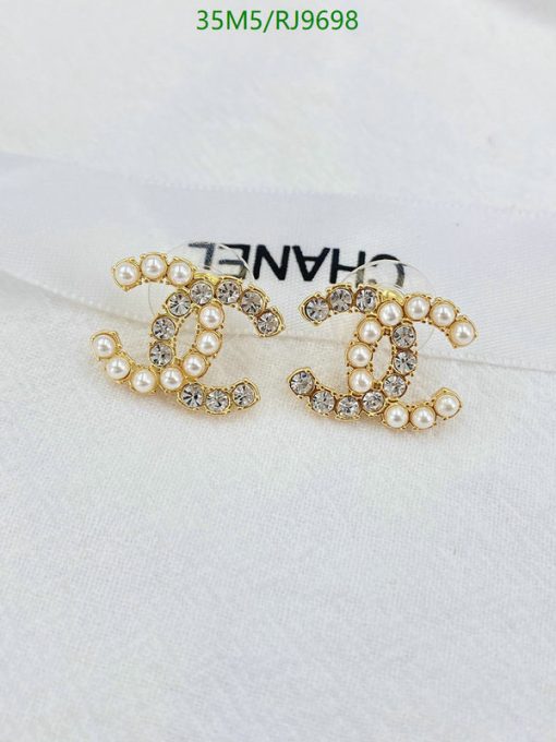 Pearl and rhinestone embellished earrings on fabric.