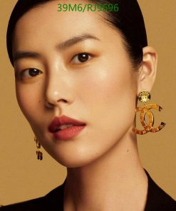 Woman with statement earrings and bold makeup.