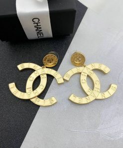 Designer gold-tone logo earrings with packaging.