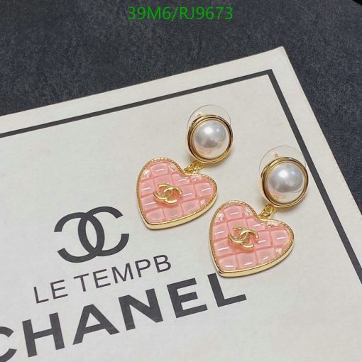 Pink heart Chanel earrings on branded paper.