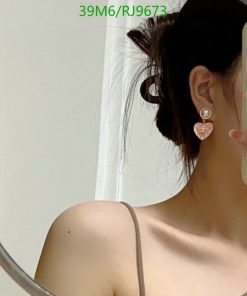 Woman with earring reflecting in mirror.