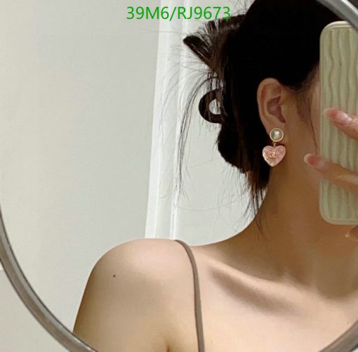 Woman with earring reflecting in mirror.