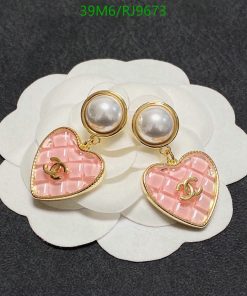 Pearl earrings with pink heart pendants on white background.