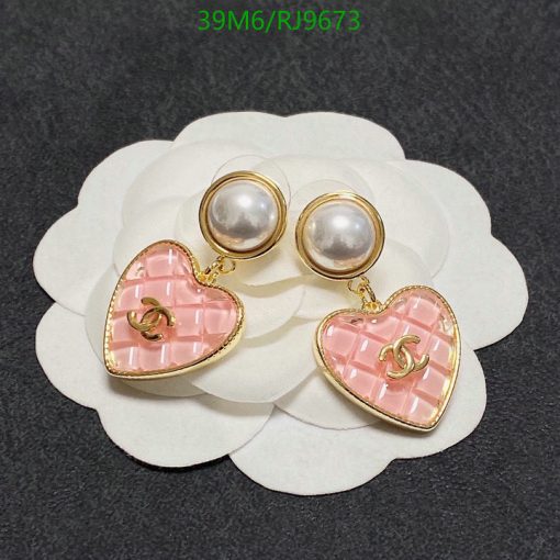 Pearl earrings with pink heart pendants on white background.