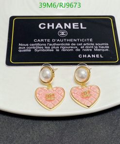 Pearl earrings with pink heart pendants and authenticity card.