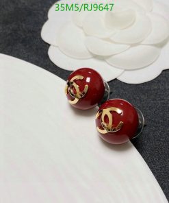 Red spherical designer stud earrings on white background.