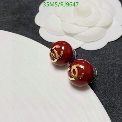 Red spherical designer stud earrings on white background.