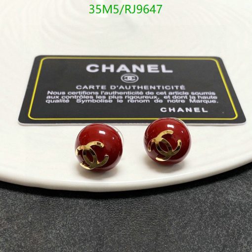 Chanel earrings and authenticity card on white surface.