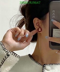 Woman showcasing earring while taking a selfie.