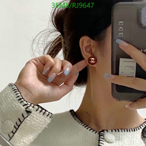 Woman showcasing earring while taking a selfie.