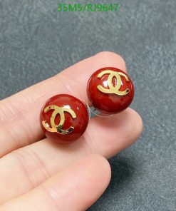 Red designer logo stud earrings in hand.