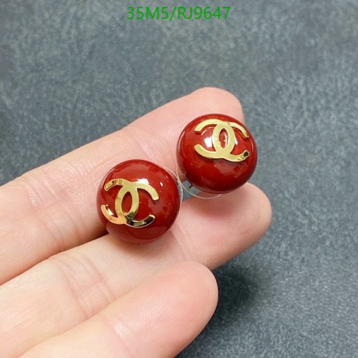 Red designer logo stud earrings in hand.