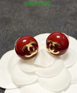 Red stud earrings on white floral backdrop.